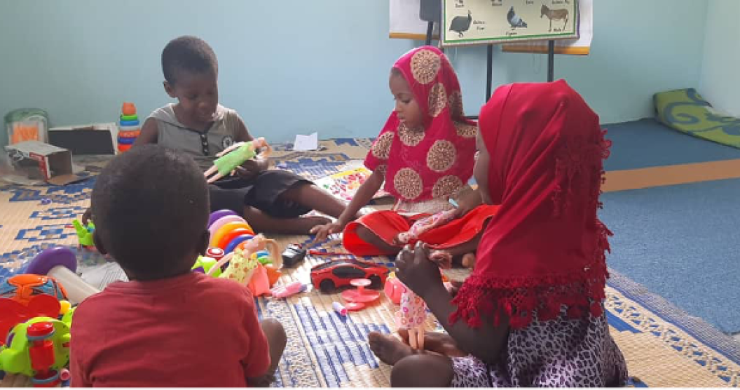 Children sit on the floor playing with toys